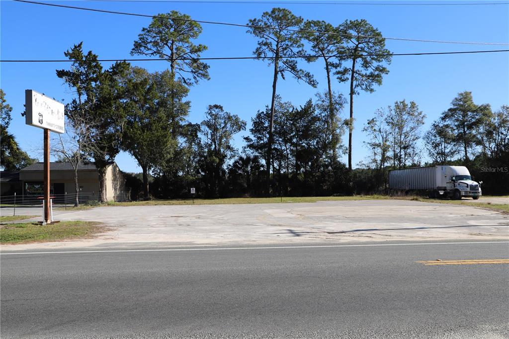 A paved commercial lot features a thrift store sign and a parked semi-truck — 850 N STATE ROAD 21, MELROSE, FL