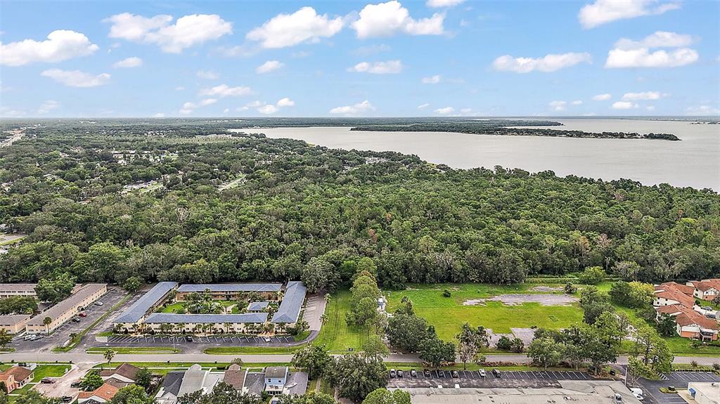 An aerial view shows a residential apartment complex, a vacant lot, and a large lake — W OAK TERRACE DRIVE, LEESBURG, FL