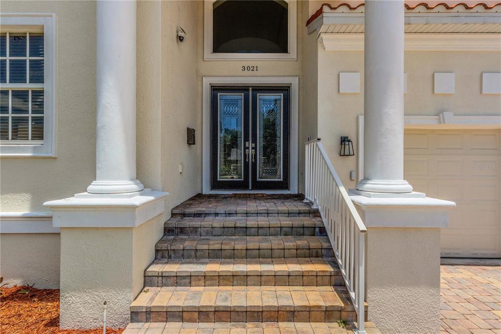 A two-story house with a paved driveway, two-car garage, and a palm tree in front — 3021 59TH AVENUE S, ST PETERSBURG, FL