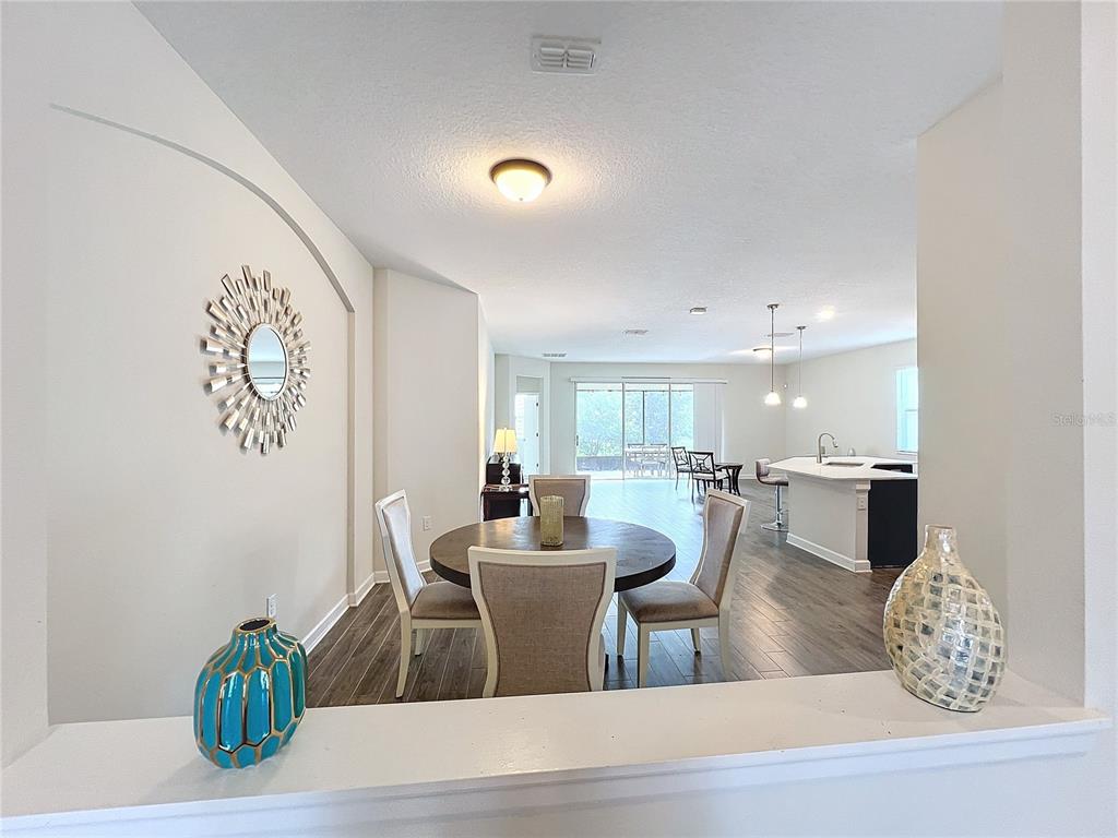 A dining area with a round table opens into a kitchen and living space — 1065 BLACKWOLF RUN RD, DAVENPORT, FL