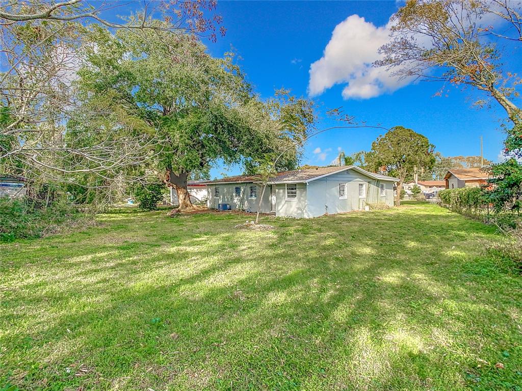 A single-story house with a concrete driveway, palm trees, and a fenced front yard — 444 SUNNYVIEW CIRCLE, ORLANDO, FL