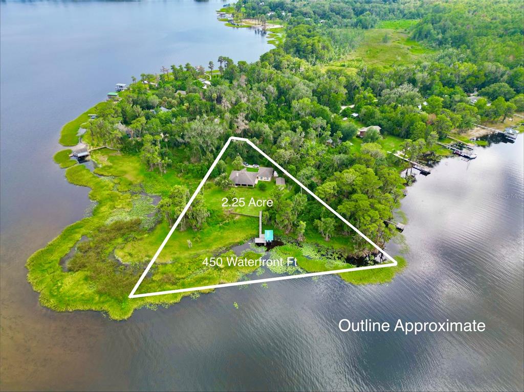 An aerial view shows a house on a triangular waterfront lot with 2.25 acres — 20924 NE 132ND AVENUE, WALDO, FL