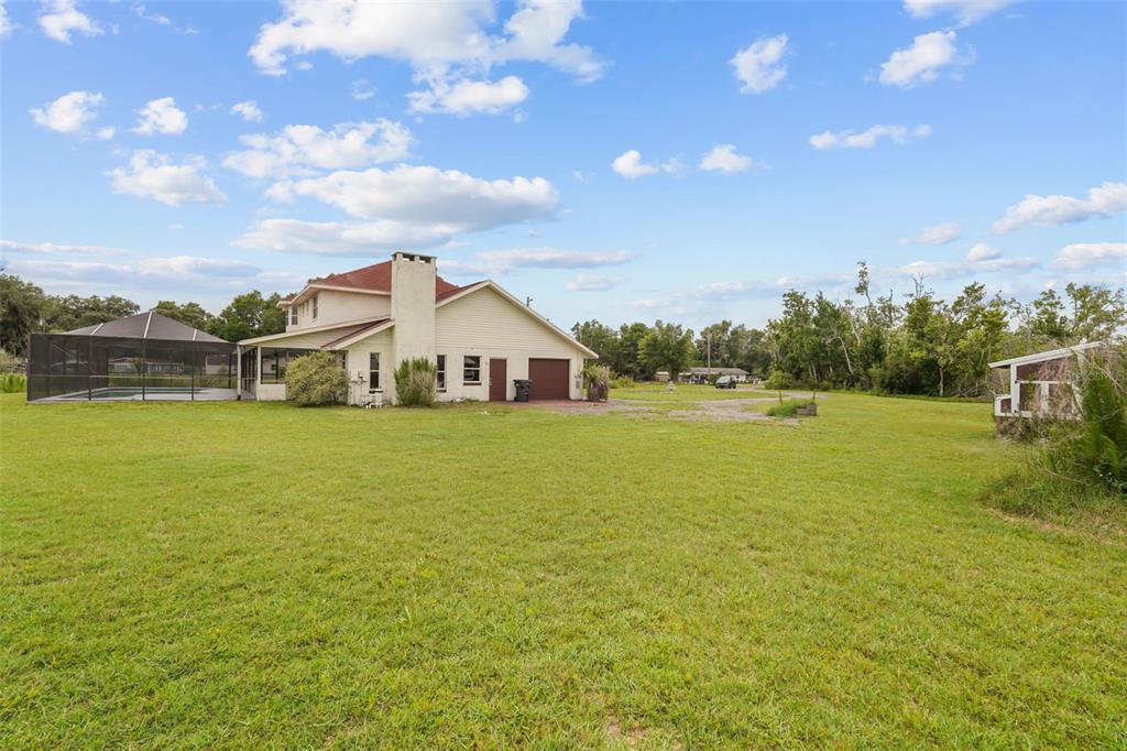 A two-story house with a screened-in pool and a large brick chimney sits on grass — 3101 LAKE LOWERY ROAD, HAINES CITY, FL