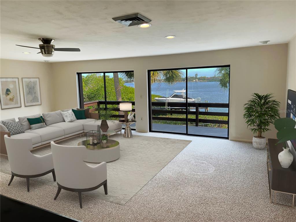 A living room features a sectional sofa, two armchairs, and sliding doors overlooking a waterfront — 1210 CASEY KEY ROAD, NOKOMIS, FL