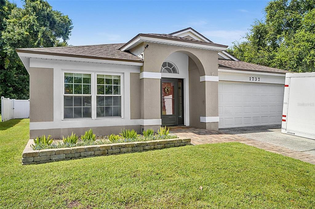 A living and dining area features hardwood floors, a neutral wall color, and dark accents — 1737 SETTING SUN LOOP, CASSELBERRY, FL