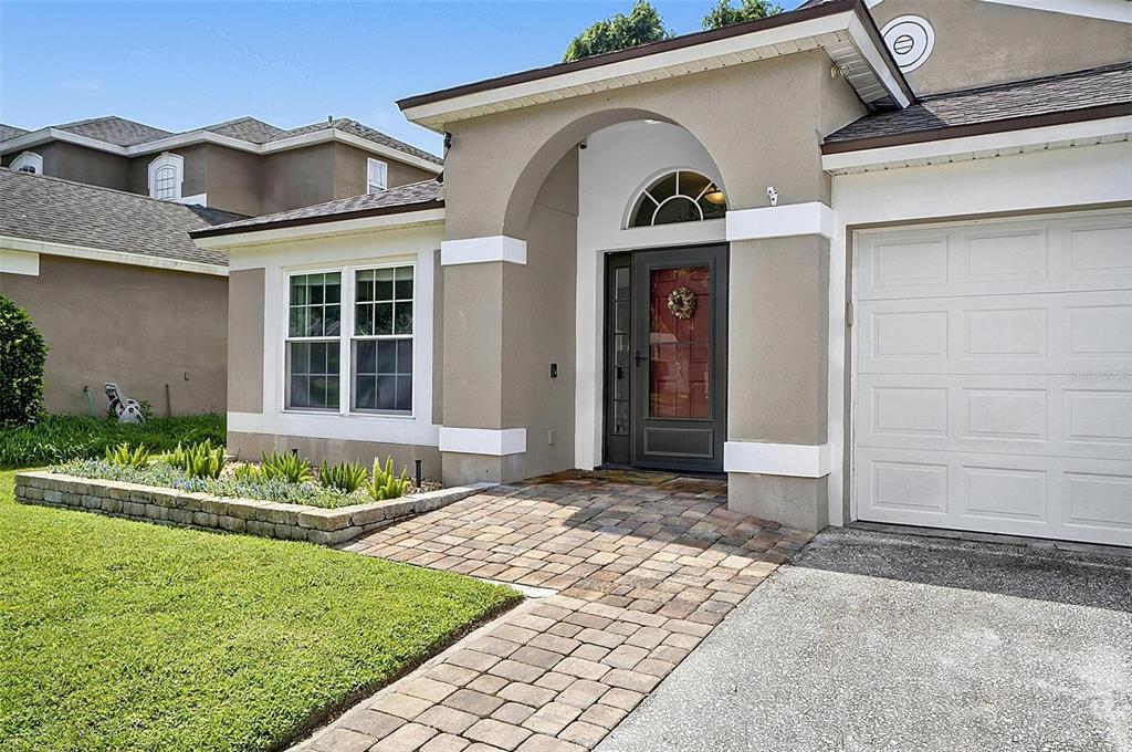A living room with hardwood floors, a large bookshelf, and an adjacent dining area — 1737 SETTING SUN LOOP, CASSELBERRY, FL