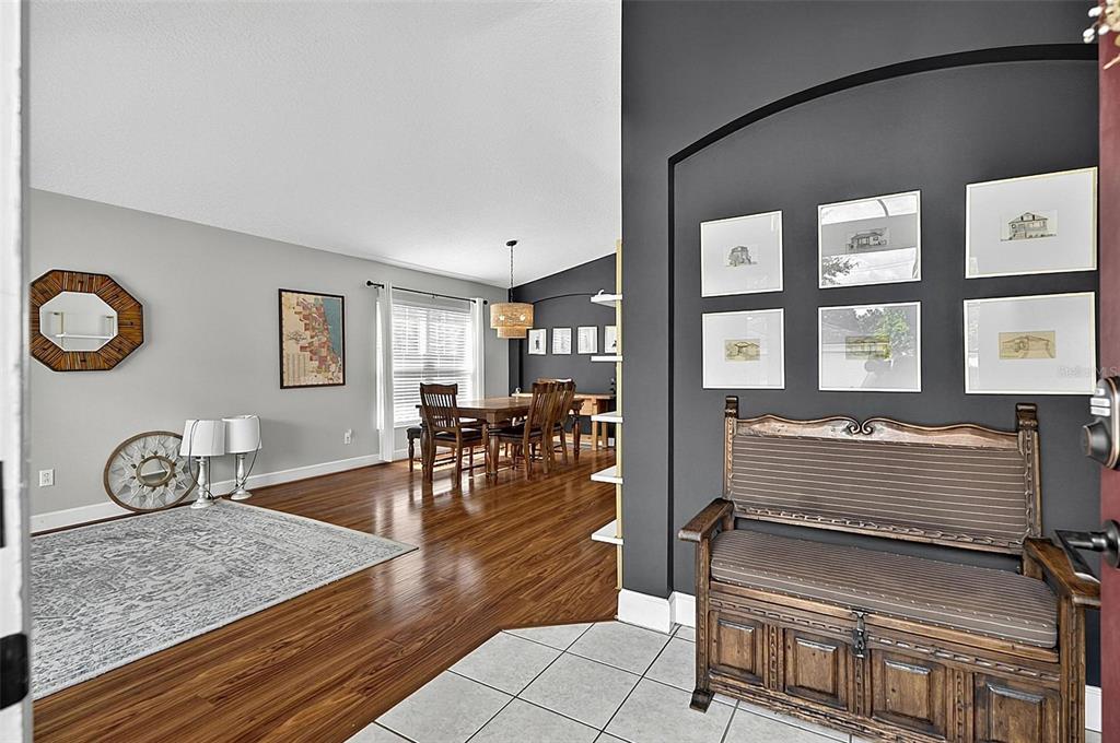 A living room features hardwood floors, a large area rug, and a front entryway — 1737 SETTING SUN LOOP, CASSELBERRY, FL