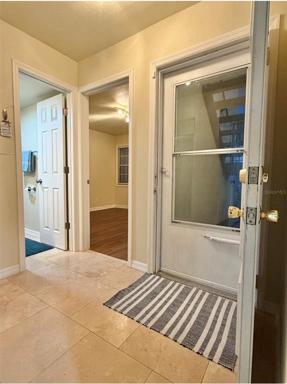 An exterior view shows a white door with a screen door and a potted plant — 3815 N OAK DRIVE UNIT G71, TAMPA, FL