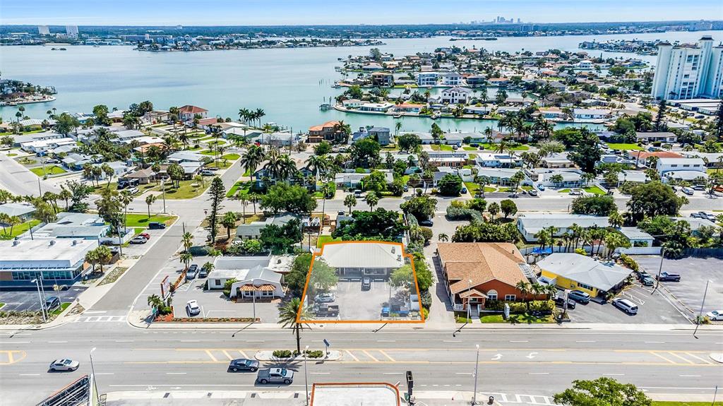 An aerial view shows a commercial building with a parking lot in a coastal neighborhood — 6655 GULF BOULEVARD, ST PETE BEACH, FL