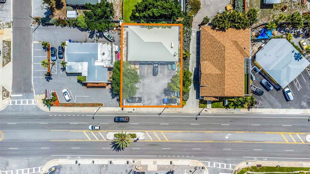 An aerial view shows a commercial building with a parking lot outlined in orange — 6655 GULF BOULEVARD, ST PETE BEACH, FL