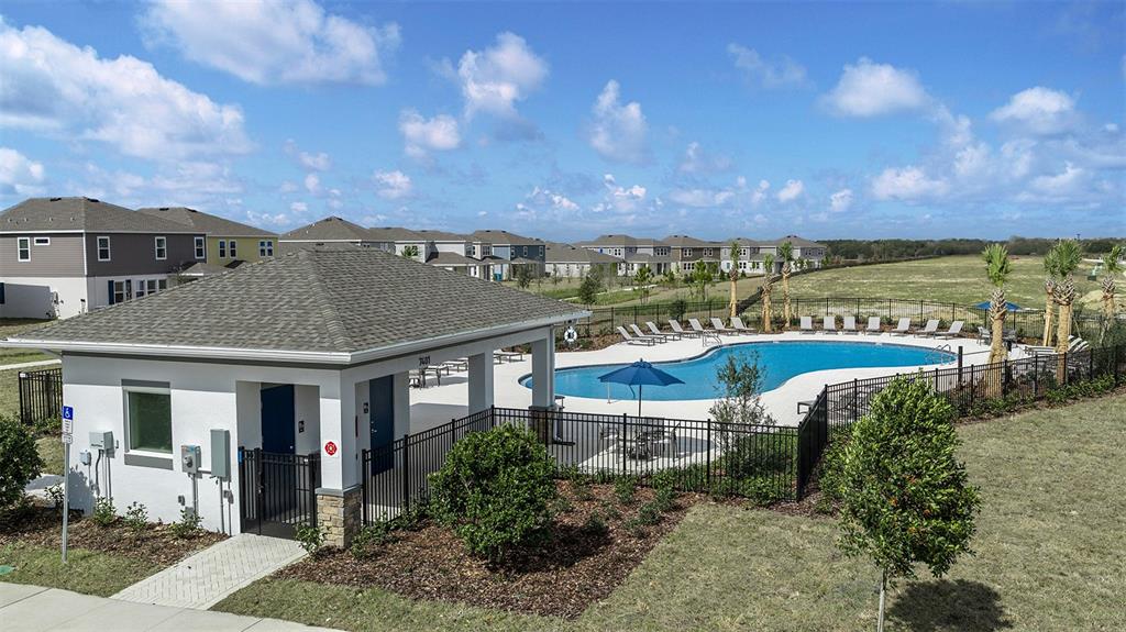 An outdoor community swimming pool with a covered pavilion and lounge chairs — 7429 FIELDSTONE DRIVE, GROVELAND, FL