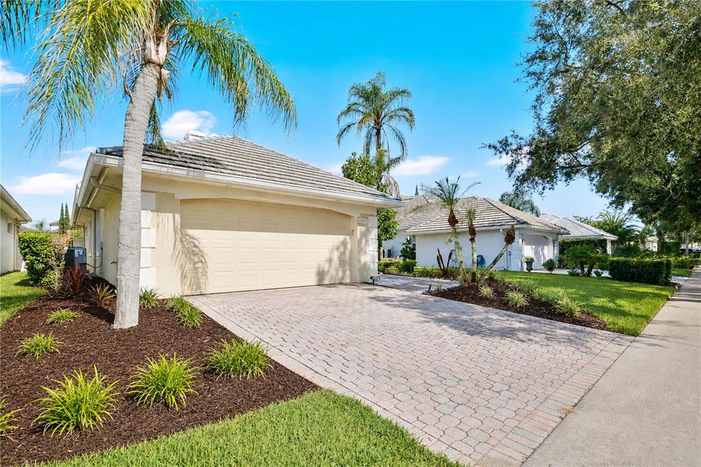 A single-story house with a beige exterior, a two-car garage, and a paved driveway — 10842 WOODCHASE CIRCLE, ORLANDO, FL
