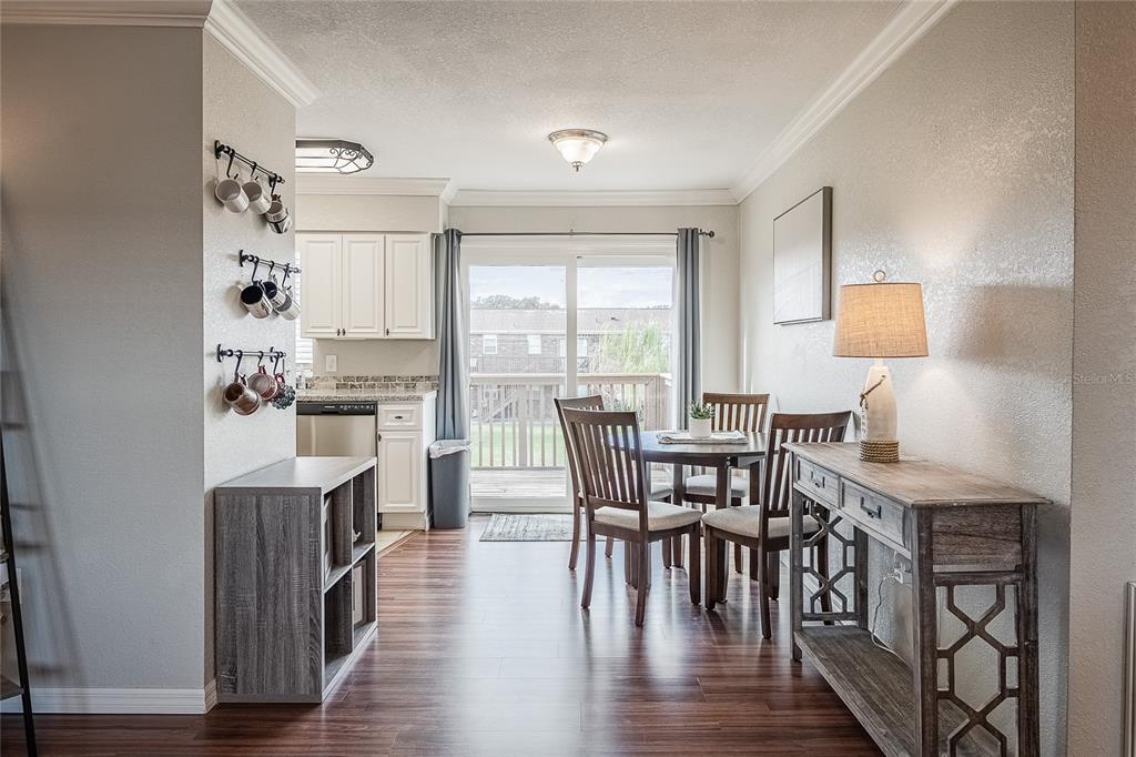 A dining area with a wooden table, chairs, and a console table near a kitchen — 1920 E EDGEWOOD DRIVE UNIT L4, LAKELAND, FL