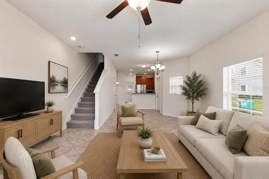 A living room with tile floors, a staircase, and an open kitchen in the background — 31141 CLARIDGE PLACE, WESLEY CHAPEL, FL