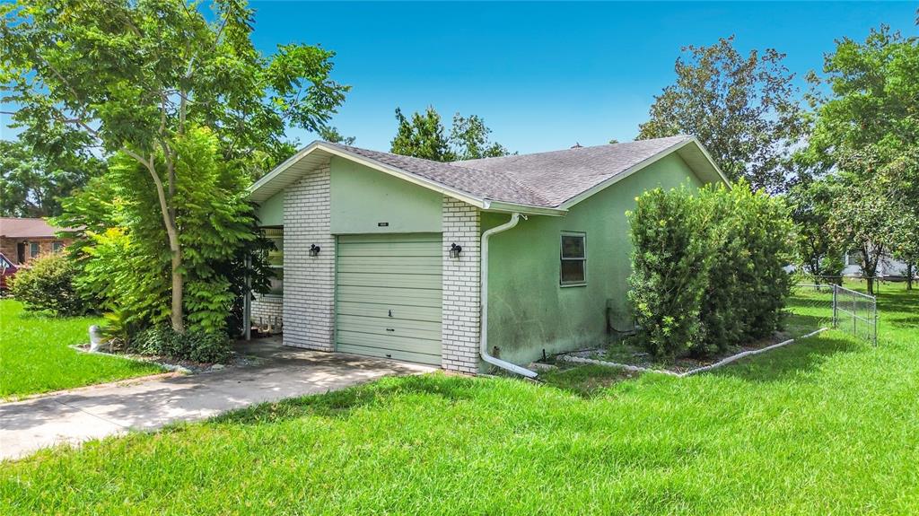 A light green detached garage with a white brick facade and a single metal door — 9320 SE MARICAMP ROAD, OCALA, FL