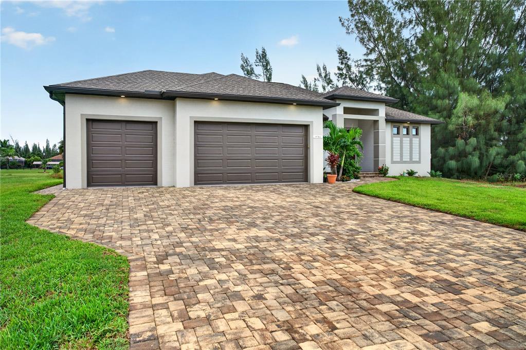 A single-story house with a paved driveway, a three-car garage, and a landscaped front yard — 15761 AQUA CIRCLE, PORT CHARLOTTE, FL