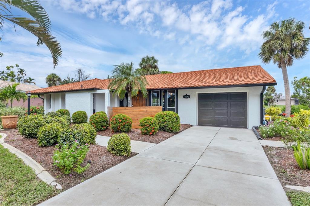A single-story house with a white exterior, orange tile roof, and a concrete driveway — 4696 POMPANO STREET, PLACIDA, FL
