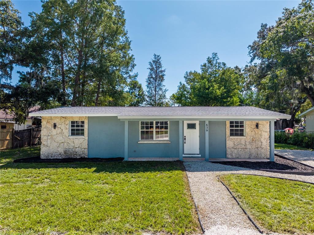 A single-story house with a blue facade, stone accents, and a gravel walkway — 639 HAND AVENUE, SARASOTA, FL