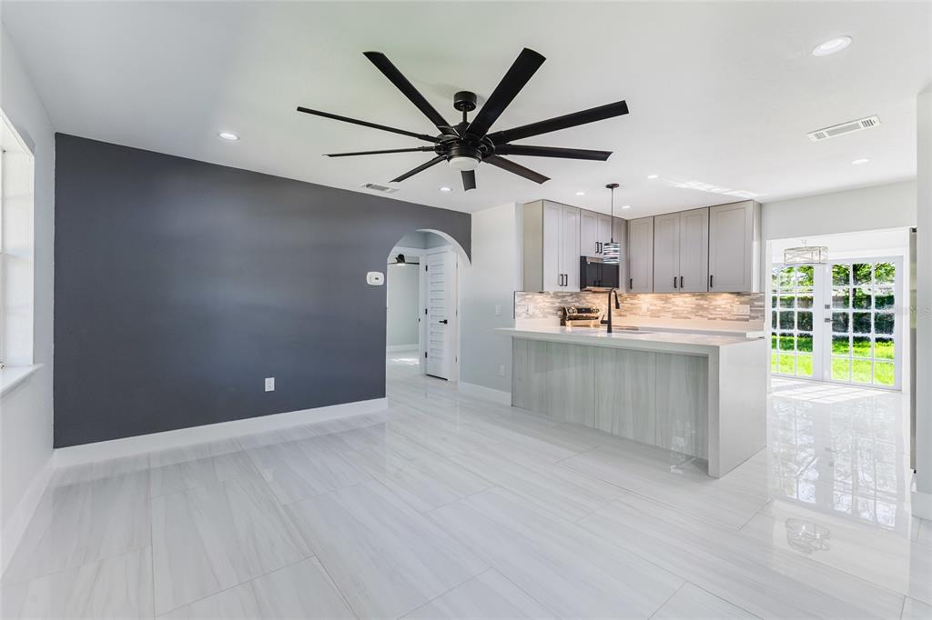 A kitchen with light gray cabinets, a white island, and a dark gray accent wall — 639 HAND AVENUE, SARASOTA, FL
