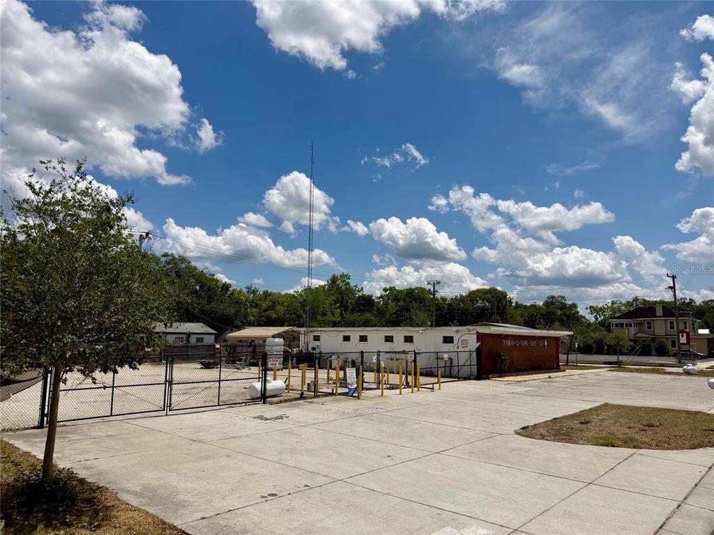 A large, unpaved gravel lot features a white van, a storage structure, and perimeter fencing — 414 W 9TH STREET, SANFORD, FL