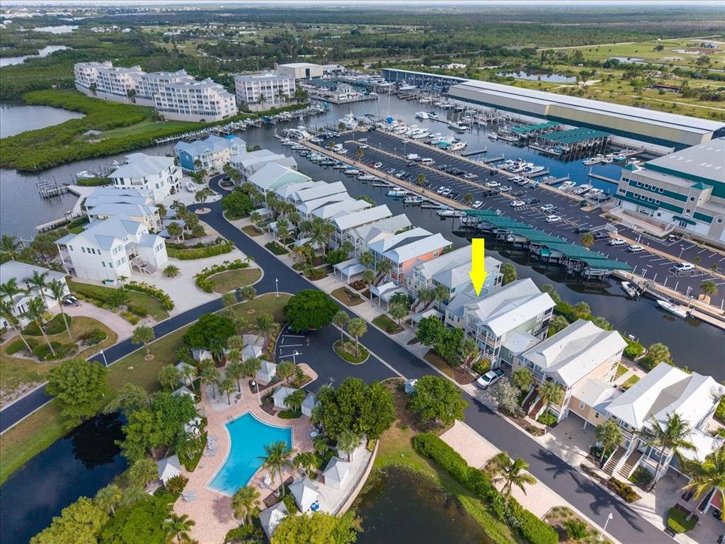 An aerial view shows a coastal residential community with a swimming pool and boat slips — 11764 ANGLERS CLUB DRIVE UNIT 111, PLACIDA, FL