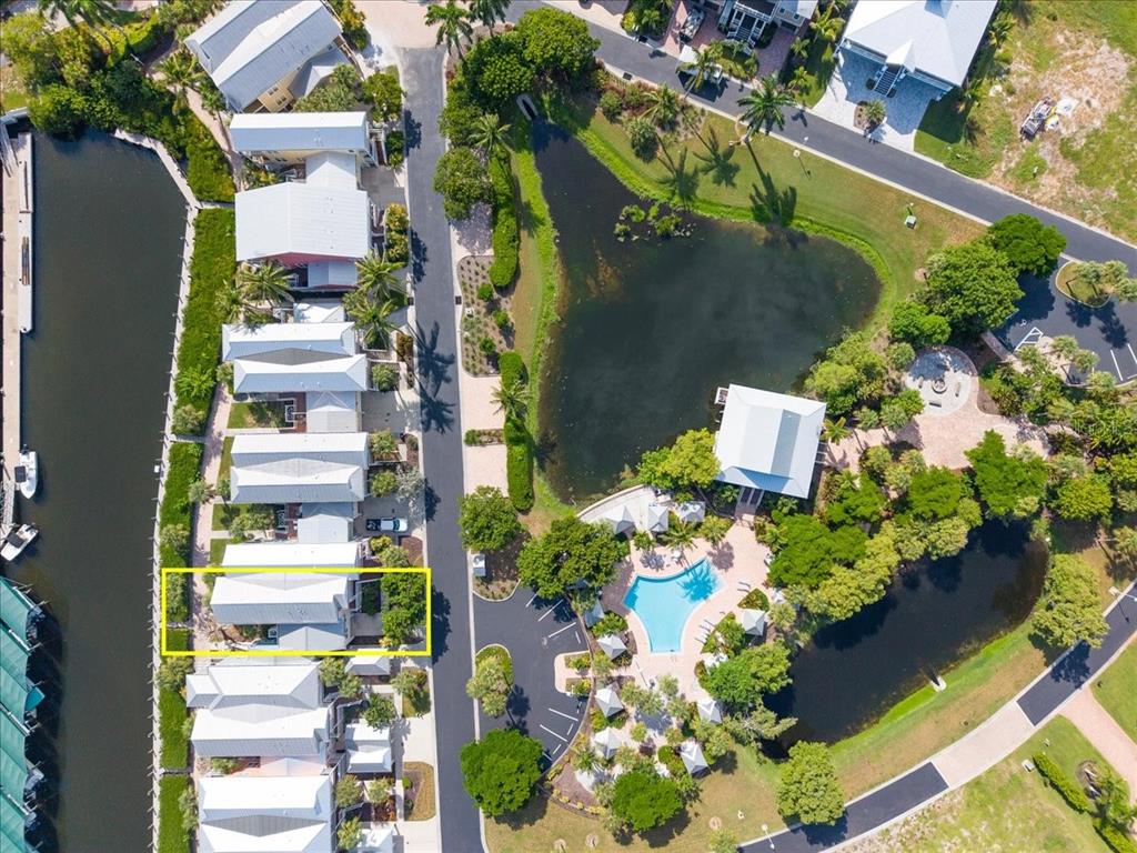An aerial view shows a row of coastal houses next to a canal and pool — 11764 ANGLERS CLUB DRIVE UNIT 111, PLACIDA, FL