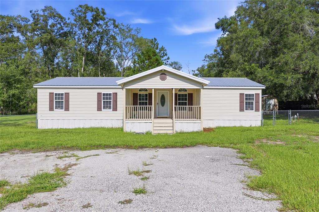 An aerial view shows a single-story house with a metal roof and a front porch — 9528 NW 235TH TERRACE, ALACHUA, FL