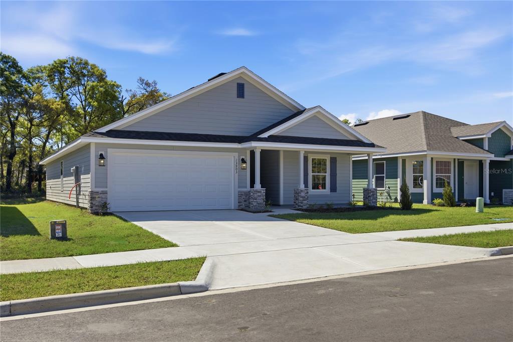A light blue single-story house with a two-car garage and a covered front porch — 2618 SW 250TH TERRACE, NEWBERRY, FL