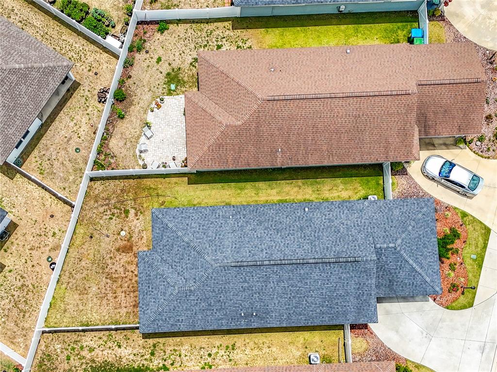 An aerial view shows two adjacent houses with shingled roofs and fenced backyards — 1885 SW 245TH TERRACE, NEWBERRY, FL