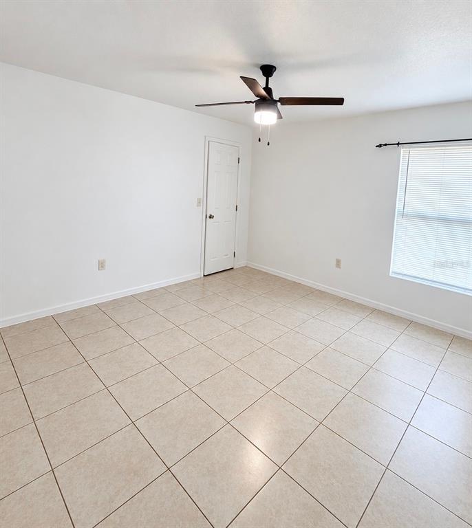 An open-concept living area features tile flooring, gray walls, and glass doors leading outside — 61 WALNUT DRIVE, OCALA, FL