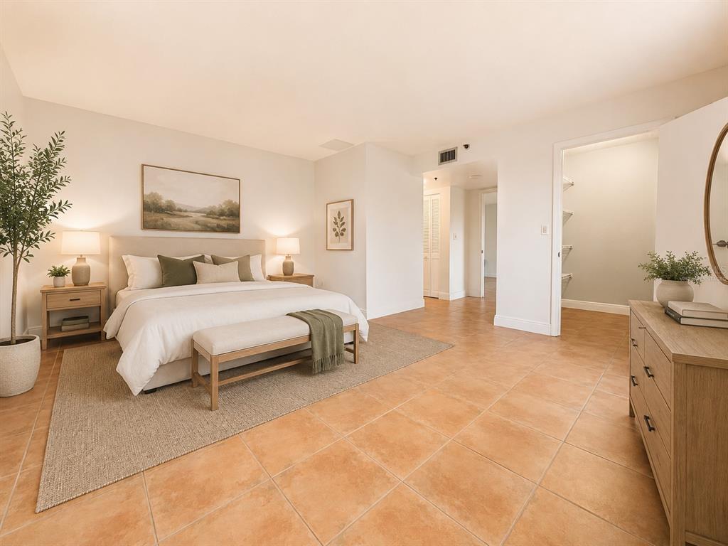 A bedroom features a king bed, neutral decor, tile flooring, and an attached walk-in closet — 1201 S OCEAN DRIVE UNIT 314S, HOLLYWOOD, FL