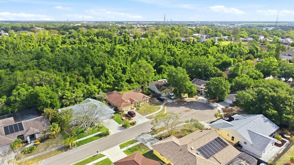 An aerial view shows a suburban cul-de-sac surrounded by dense trees and residential homes — 5599 WILDE OAK WAY, SARASOTA, FL