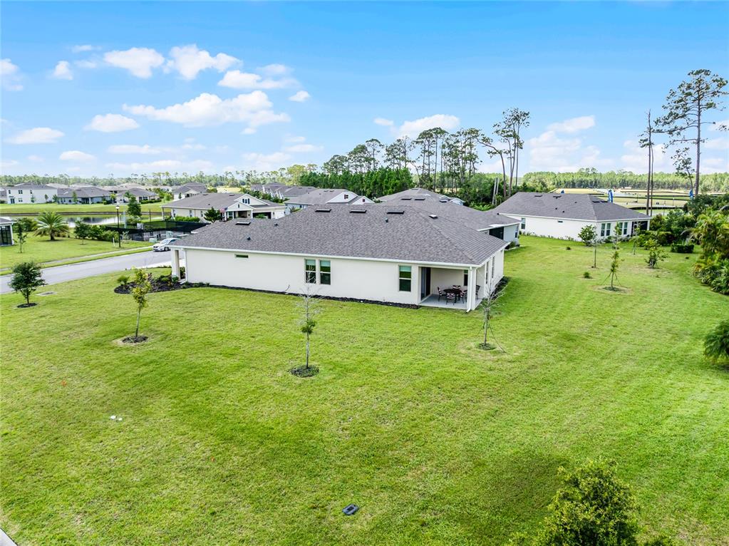 An aerial view shows the back of a single-story house with a covered patio — 2892 MONAGHAN DRIVE, ORMOND BEACH, FL
