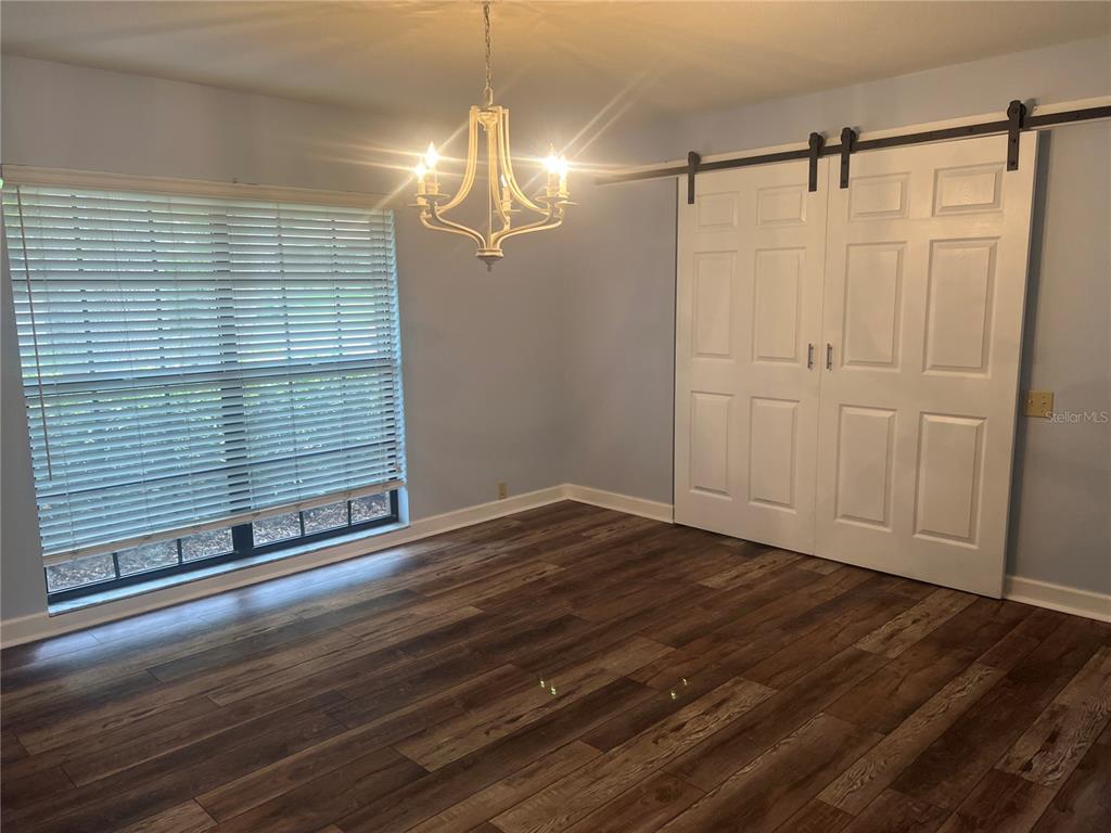 An entryway features a wood-paneled front door, white walls, and wood-look flooring — 1101 OAKRIDGE MANOR DRIVE, BRANDON, FL