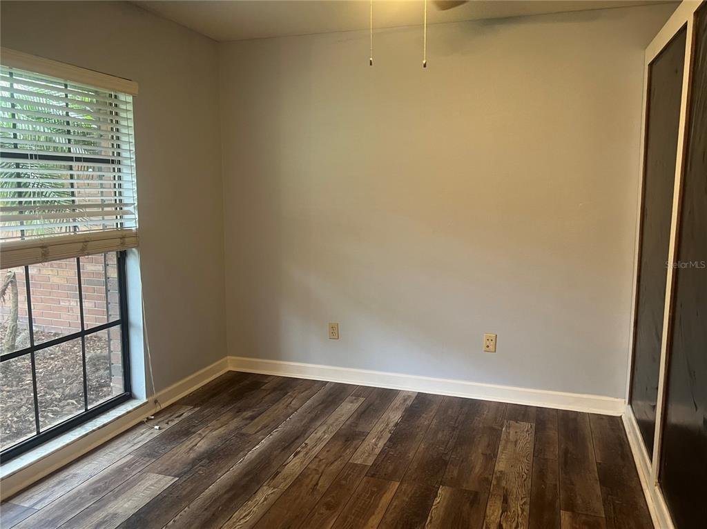 A dining room features wood-look flooring, a white chandelier, and white sliding barn doors — 1101 OAKRIDGE MANOR DRIVE, BRANDON, FL