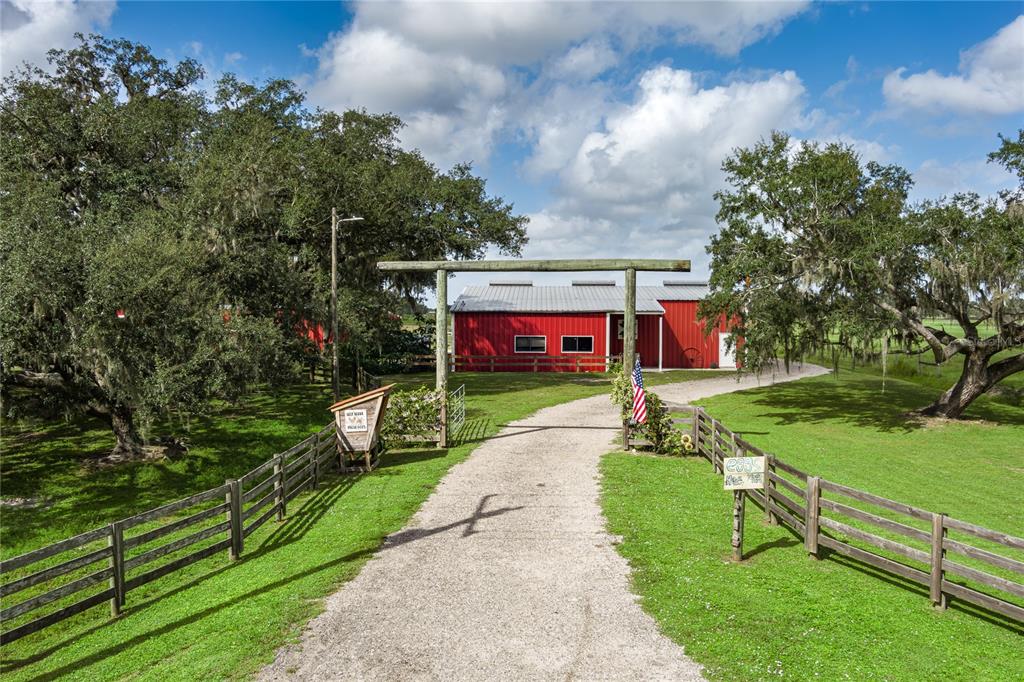 Two horses stand in a dirt paddock enclosed by a wooden fence under a cloudy sky — 1126 COUNTY ROAD 665, ONA, FL