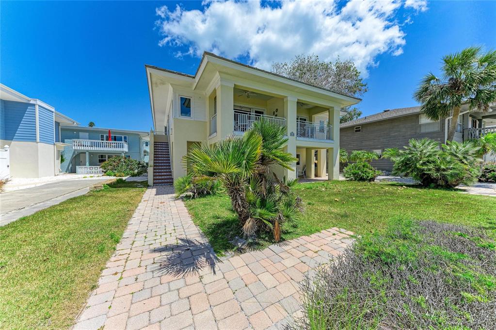 A two-story yellow house with a paved walkway and palm trees in the front yard — 101 PALM AVENUE UNIT 1, ANNA MARIA, FL