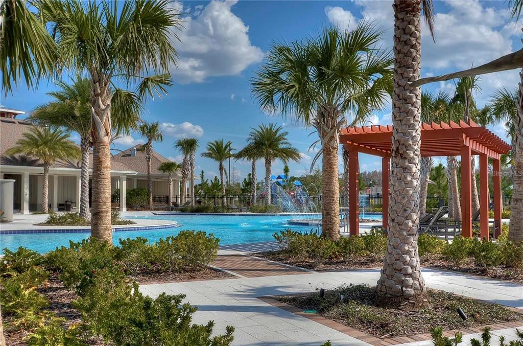 A swimming pool with a fountain and a wooden pergola surrounded by palm trees — 15407 LOST CREEK LANE, RUSKIN, FL