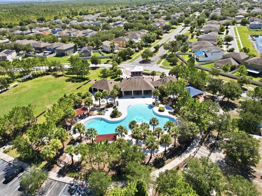 An aerial view of a community clubhouse featuring a large swimming pool and surrounding landscaping — 15407 LOST CREEK LANE, RUSKIN, FL