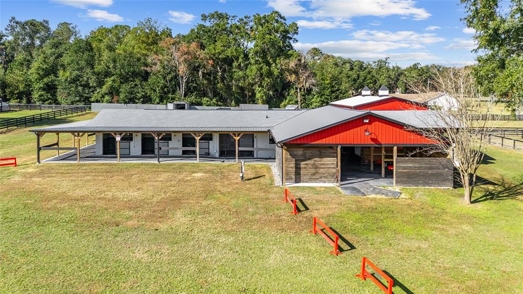 An aerial view of a horse barn with a red metal roof and stalls — 2 COUNT FLEET DRIVE, OCALA, FL