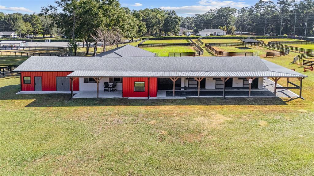 An aerial view shows a red and white horse barn with a covered porch — 2 COUNT FLEET DRIVE, OCALA, FL