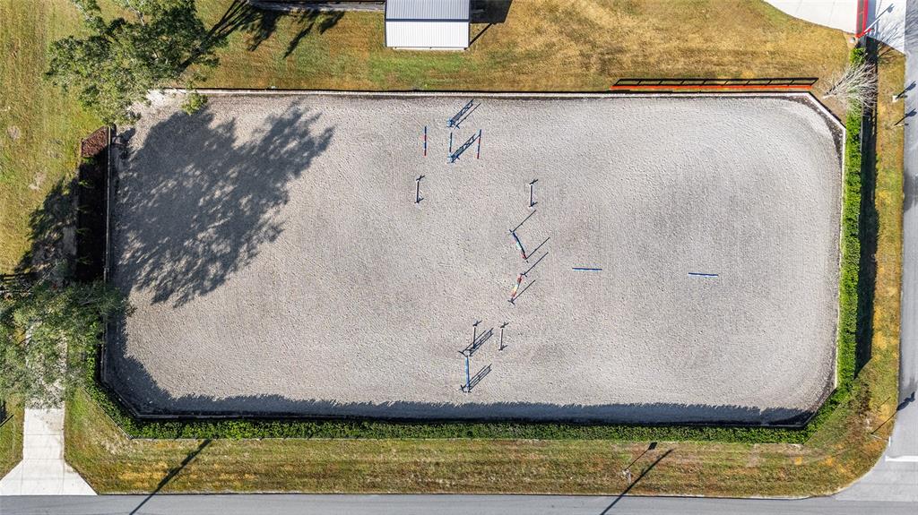 An aerial view shows a rectangular horse riding arena with several jumps set up inside — 2 COUNT FLEET DRIVE, OCALA, FL