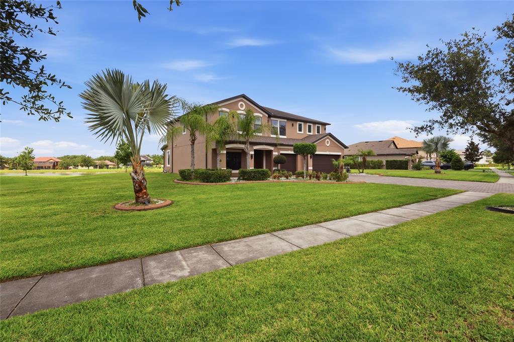 A two-story house with a paved driveway, two garage doors, and a green lawn — 9410 LISBON STREET, SEFFNER, FL