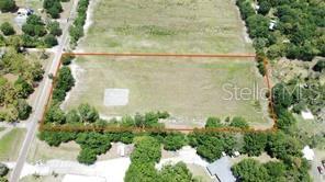 An aerial view shows a rectangular, grassy vacant lot outlined in orange — 1702 30TH STREET SE, RUSKIN, FL