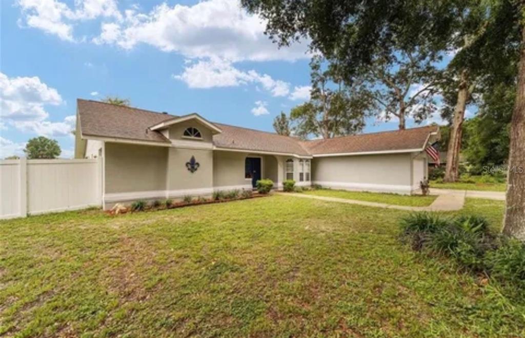 A single-story house with a light green exterior, a brown roof, and a front lawn — 3322 SE 55TH COURT, OCALA, FL