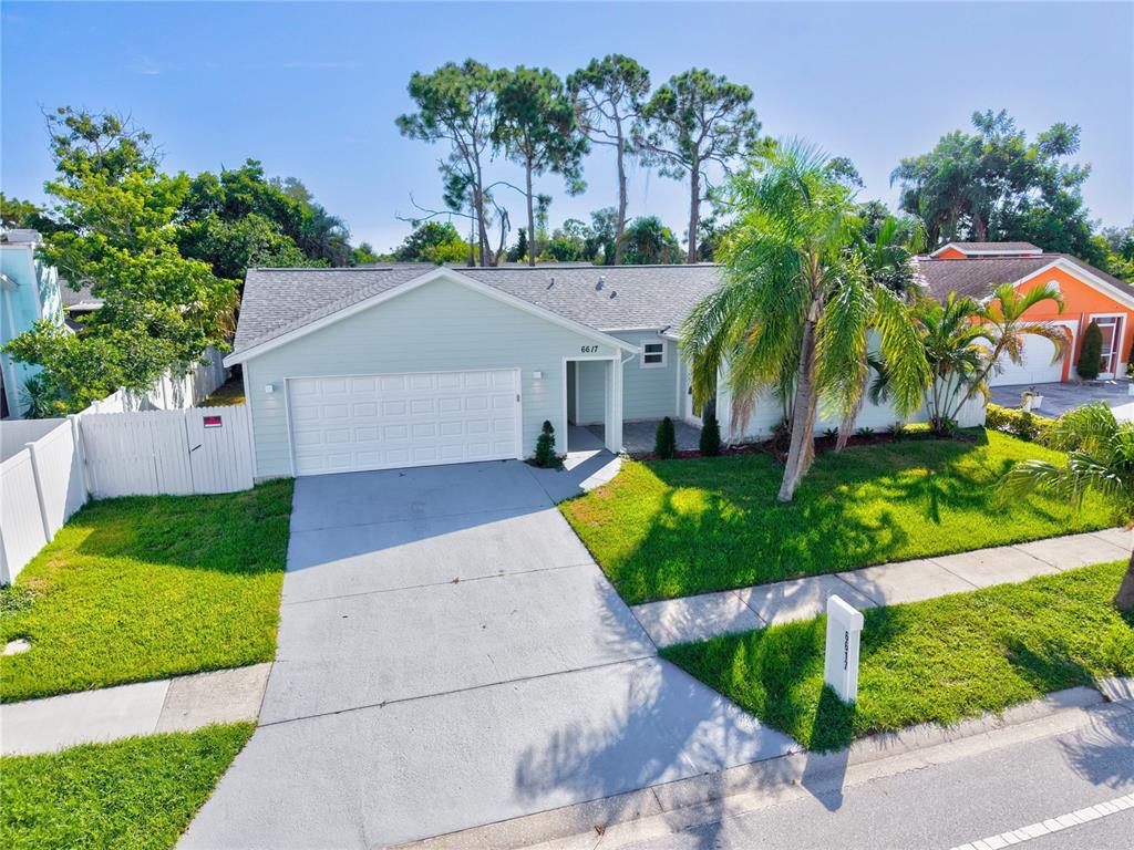 A light green single-story house with a two-car garage, driveway, and palm tree in front — 6617 MAUNA LOA BOULEVARD, SARASOTA, FL