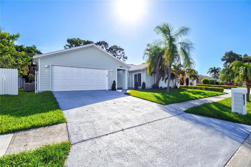 A light green single-story house with a two-car garage and a concrete driveway — 6617 MAUNA LOA BOULEVARD, SARASOTA, FL