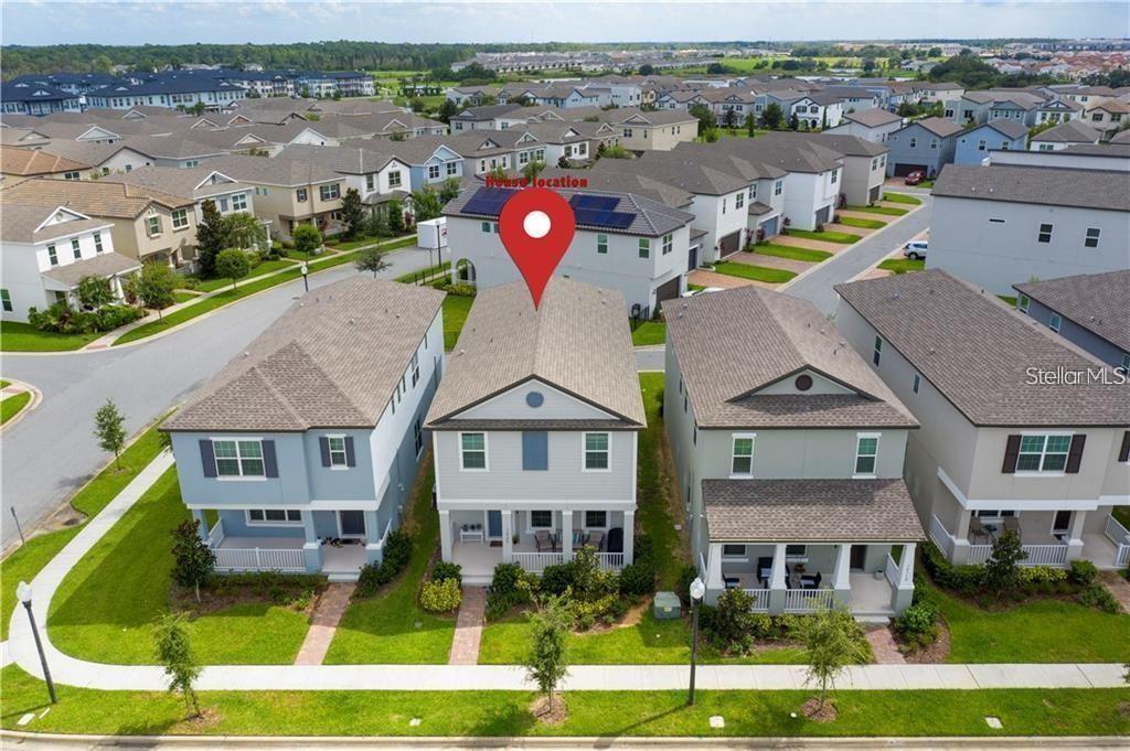 The exterior of a house features a blue front door, white railings, and green bushes — 14704 SETON CREEK BOULEVARD, WINTER GARDEN, FL