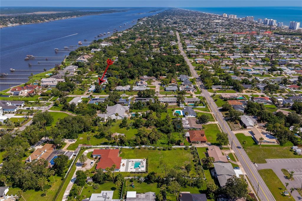 A bright turquoise house exterior features a white porch with a painted compass rose design — 697 JOHN ANDERSON DRIVE, ORMOND BEACH, FL