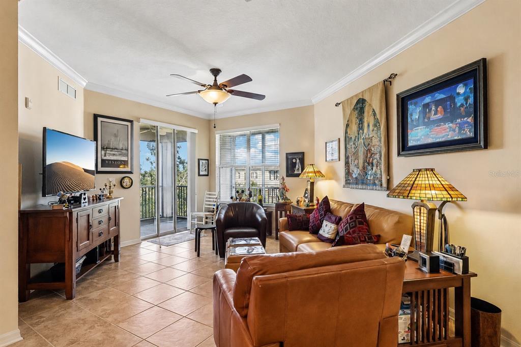 A living room features tile flooring, a leather sofa, a ceiling fan, and a sliding glass door — 8168 BOAT HOOK LOOP UNIT 303, WINDERMERE, FL